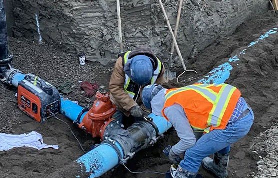 Crew fitting a water main valve assembly on a RockHard civil trench site